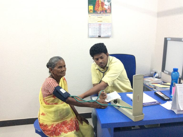 Dr. Sathish examining the patient in the medical camp.