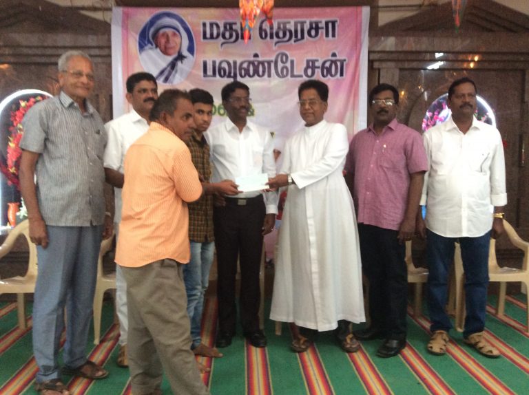 Rev. Fr. Periyanna handing over cheque to Selvan. Muthuraman on behalf of our Foundation