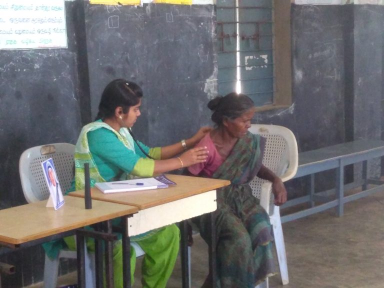 Doctor examining the patient during free rural medical camp.